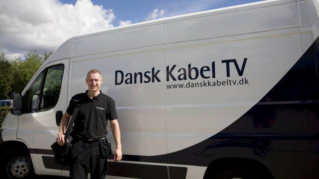 Mand foran bil fra Dansk Kabel TV, som har fået migreret to netværk til ét hurtigt og mere robust carrier-grade netværk.
